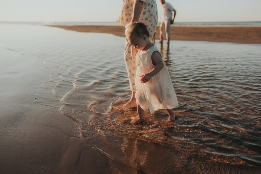 Family explores a PEI beach while taking family photos.