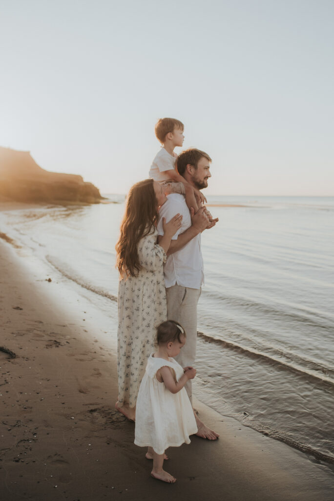 Family explores a PEI beach while taking family photos.