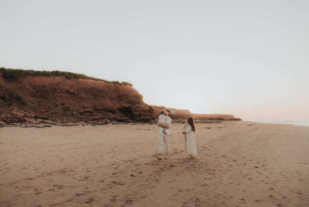 Family explores a PEI beach while taking family photos.